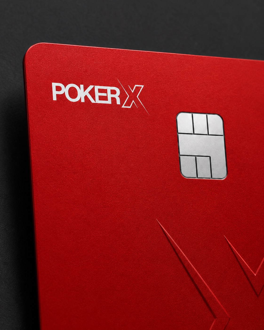 Macro detail of the POKER X Card — brushed steel chip and embossed X